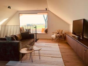 a living room with a couch and a tv at Vakantiewoning Vaib in Kortemark