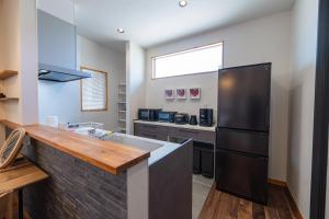 a kitchen with a black refrigerator and a counter at Miyako Island Breeze in Miyako-jima