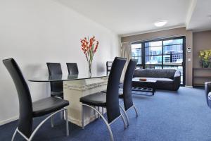 een eetkamer met een tafel en zwarte stoelen bij HarbourView Apartment Hotel (now Arrow on Spencer) in Melbourne