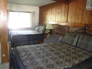 a bedroom with two beds and a window at Kern Riverfront Lodge in Kernville