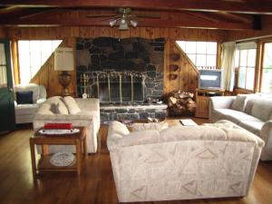 a living room with two couches and a stone fireplace at Kern Riverfront Lodge in Kernville