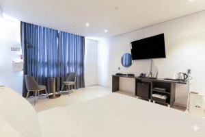 a hotel room with a bed and a flat screen tv at Hotel Deokyeong in Wonju