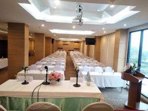 a banquet hall with white tables and white chairs at S Tara Grand in Suratthani