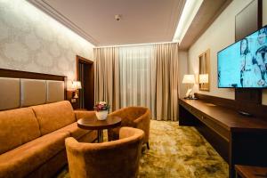 ein Hotelzimmer mit Sofa und Flachbildfernseher in der Unterkunft Wellness & Spa Hotel Kaskady in Sliač