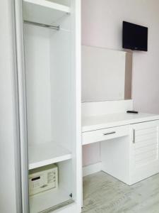 a kitchen with white cabinets and a tv on the wall at Beachway Hotel in Side