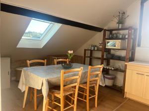 a dining room with a table with chairs and a window at Sur les Toits de Honfleur in Honfleur