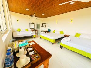 a large room with two beds and a table at Sigiriya Water Guest & View Point Restaurant in Sigiriya