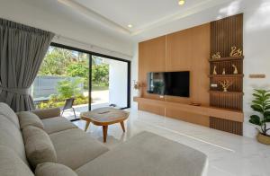 a living room with a couch and a tv at Samui Kozy Private Pool Villa in Nathon Bay