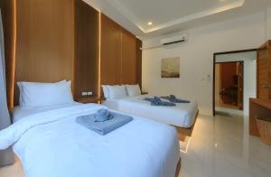 two beds in a hotel room with towels on them at Samui Kozy Private Pool Villa in Nathon Bay +19 photos
