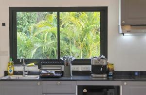 a kitchen counter with a window and a sink at Samui Kozy Private Pool Villa in Nathon Bay