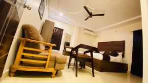 a bedroom with a bed and a desk and a chair at HOTEL classic in Visakhapatnam