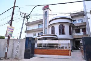 a white building with a gate in front of it at Hotel Pinaka in Pratāpgarh +26 photos