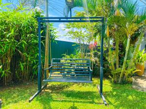 a blue swing in a yard with plants at Sigiriya Water Guest & View Point Restaurant in Sigiriya