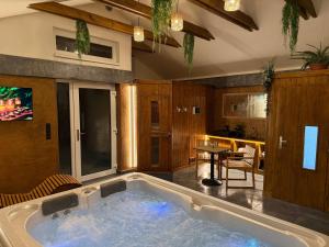 a large bath tub in a room with a kitchen at Bungalovy CLASSIC & Wellness Podhájska - Adults Only in Podhájska