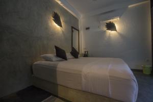 una camera da letto con un letto con due luci sul muro di Explore Sinharaja Rain Forest Tour Camp a Dombagoda