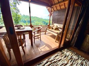 a room with a balcony with a table and chairs at Whispering Hills in Perean