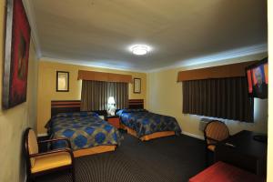 a hotel room with two beds and a television at King Motel - Miami in Miami