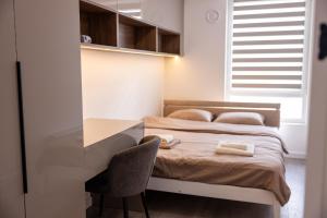 a bedroom with a bed with a desk and a chair at Apartaments Parking Taxi in Chişinău
