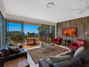 a living room filled with furniture and a large window at Avoca Palms Resort in Avoca Beach
