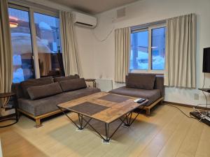 a living room with a couch and a table at KitaのHikari in Sapporo