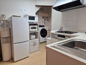 a kitchen with a white refrigerator and a sink at KitaのHikari in Sapporo