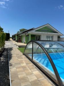 a swimming pool with a glass bridge next to a house at Bungalovy CLASSIC & Wellness Podhájska - Adults Only in Podhájska