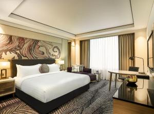 a hotel room with a bed and a desk at Amari Johor Bahru in Johor Bahru