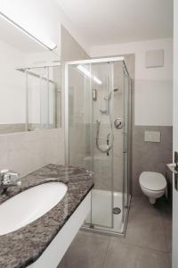 a bathroom with a shower and a sink and a toilet at Zeder Kraiterhof in Andrian +18 photos