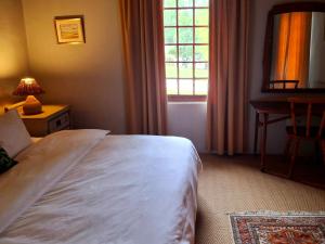 a bedroom with a large white bed and a window at Schalkenbosch Farm Cottages in Tulbagh +37 photos