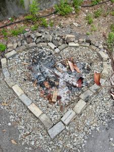 a fire pit in the ground with rocks and rubble at Liv Bumi Oasis in Pantai Cenang