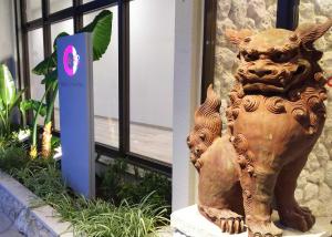 a statue of a dog sitting in front of a building at Community & Spa Naha Central Hotel in Naha