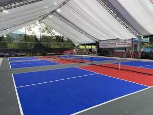 a tennis court with blue and red tennis courts at Truong Xuan Ecolodge in Ha Giang