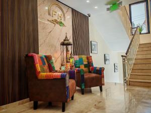a living room with two chairs and a staircase at Friends Hotel Jordan in Amman