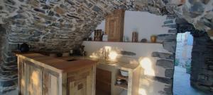 a kitchen with a counter and a stone wall at MAS Estrela Chambre Lo Roc in Bessèges