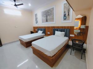 a hotel room with two beds and a chair at Hotel Orchha Heritage in Orchha