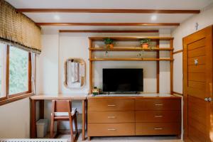 a room with a desk and a tv and a table at Katig Beachfront Boutique Hotel in General Luna