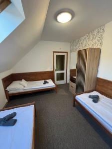 a room with two beds and a mirror at Kormorán Vendégház in Matty