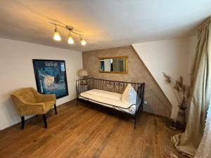 a bedroom with a crib and a chair in a room at Appartement Rothenburg in Rothenburg ob der Tauber