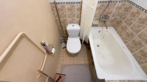 a small bathroom with a toilet and a tub at Апартаменты 3а in Aktau +3 photos