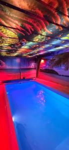 a pool in a room with a colorful ceiling at ZAJAZD ALBATROS Rzeszów APARTAMENTY SPA in Rzeszów