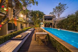 a resort pool with tables and chairs next to a building at cooldowns resort maerim chiangmai in Ban Thung Pong