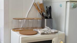 a white microwave with wooden plates and utensils at Апартаменты 3а in Aktau