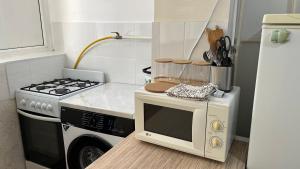 a small kitchen with a stove and a microwave at Апартаменты 3а in Aktau