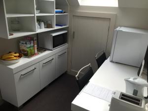 a kitchen with a table with a microwave and a white counter at Davidsons Luxury Homestay in Lower Hutt