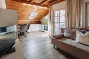 a living room with a couch and a kitchen at Zeder Kraiterhof in Andrian
