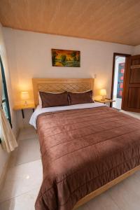 a bedroom with a large bed in a room at La Casita de Carpintero in Cucunubá