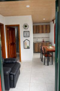 a living room and kitchen with a table and a couch at La Casita de Carpintero in Cucunubá +10 photos