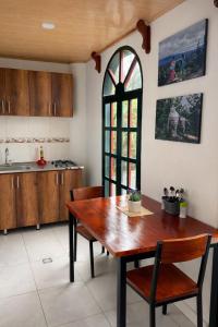 a kitchen with a wooden table and chairs and a window at La Casita de Carpintero in Cucunubá