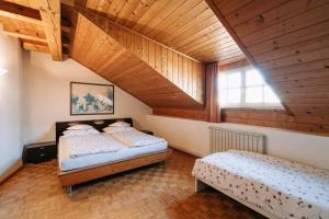two beds in a room with a wooden ceiling at Zeder Kraiterhof in Andrian