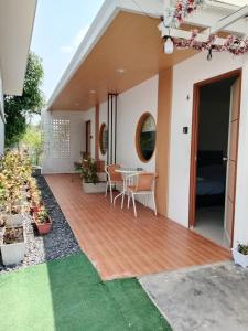 a house with a wooden deck with a table at มานอนนี่ รีสอร์ท in Ban Wang Thong